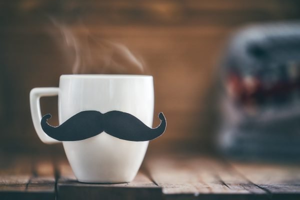 Cup of coffee with a moustache. steam rising from the cup.